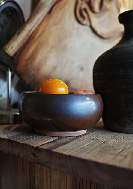 A close-up shot of a set of crystal singing bowls of various sizes and colors, each emitting a soft, glowing light, placed on a wooden surface with mallets nearby.